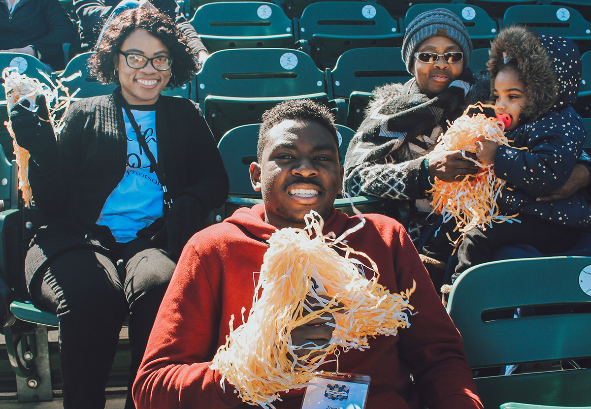 African American family sitting at a baseball game.