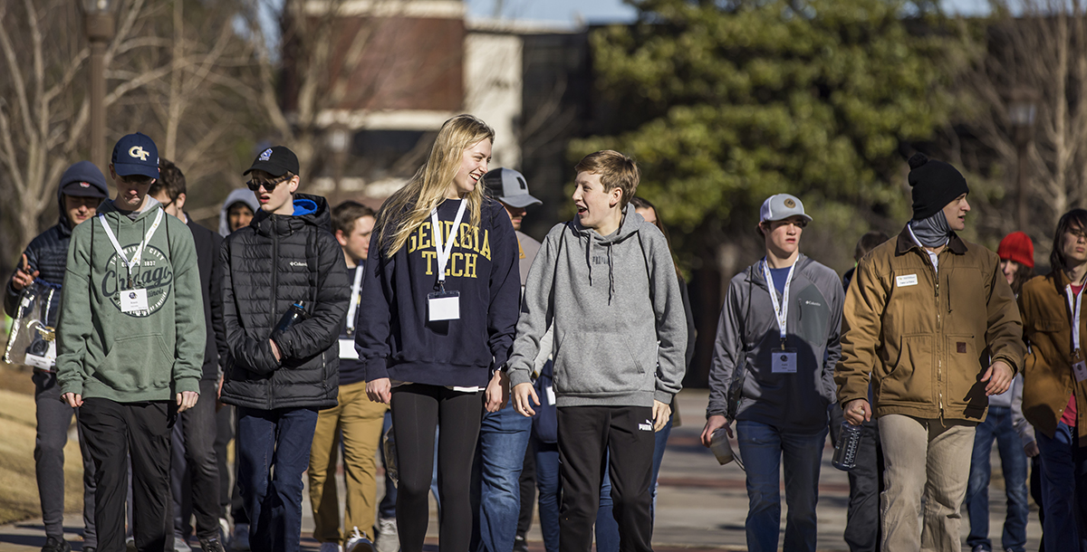 A group of students walk outside on a wide pathway